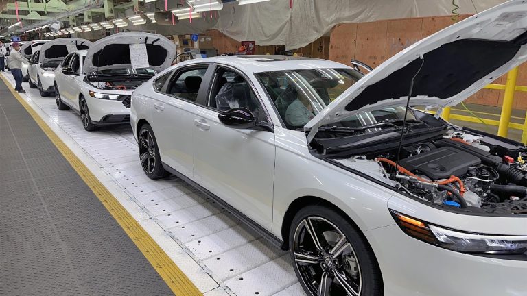 Honda hybrid cars moving through an assembly line during factory production