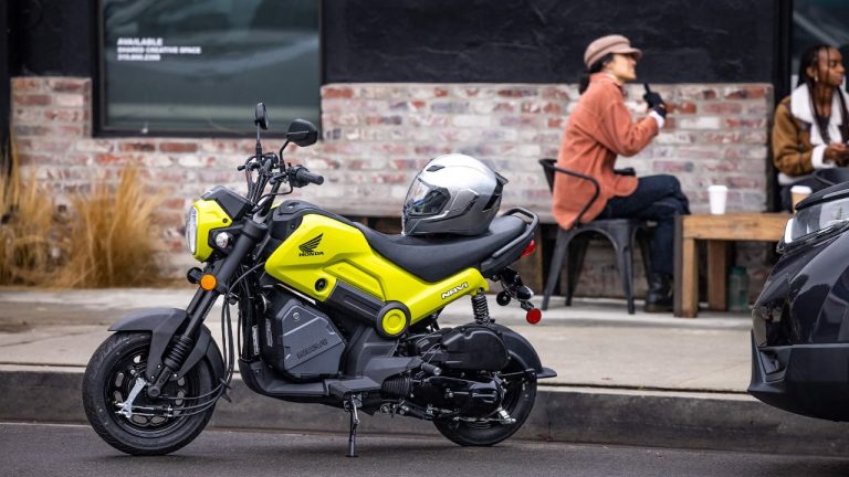 Honda Navi parked outside a café with a helmet resting on its seat