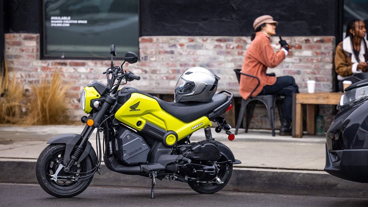Honda Navi parked outside a café with a helmet resting on its seat