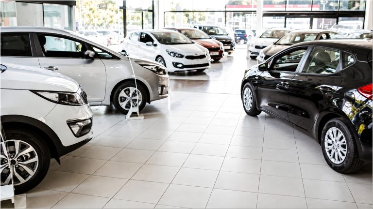 Cars in a dealership showroom with polished floors visible