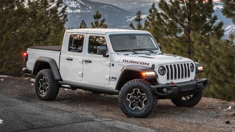 Jeep Gladiator Rubicon parked on a rugged mountain road surrounded by pine trees