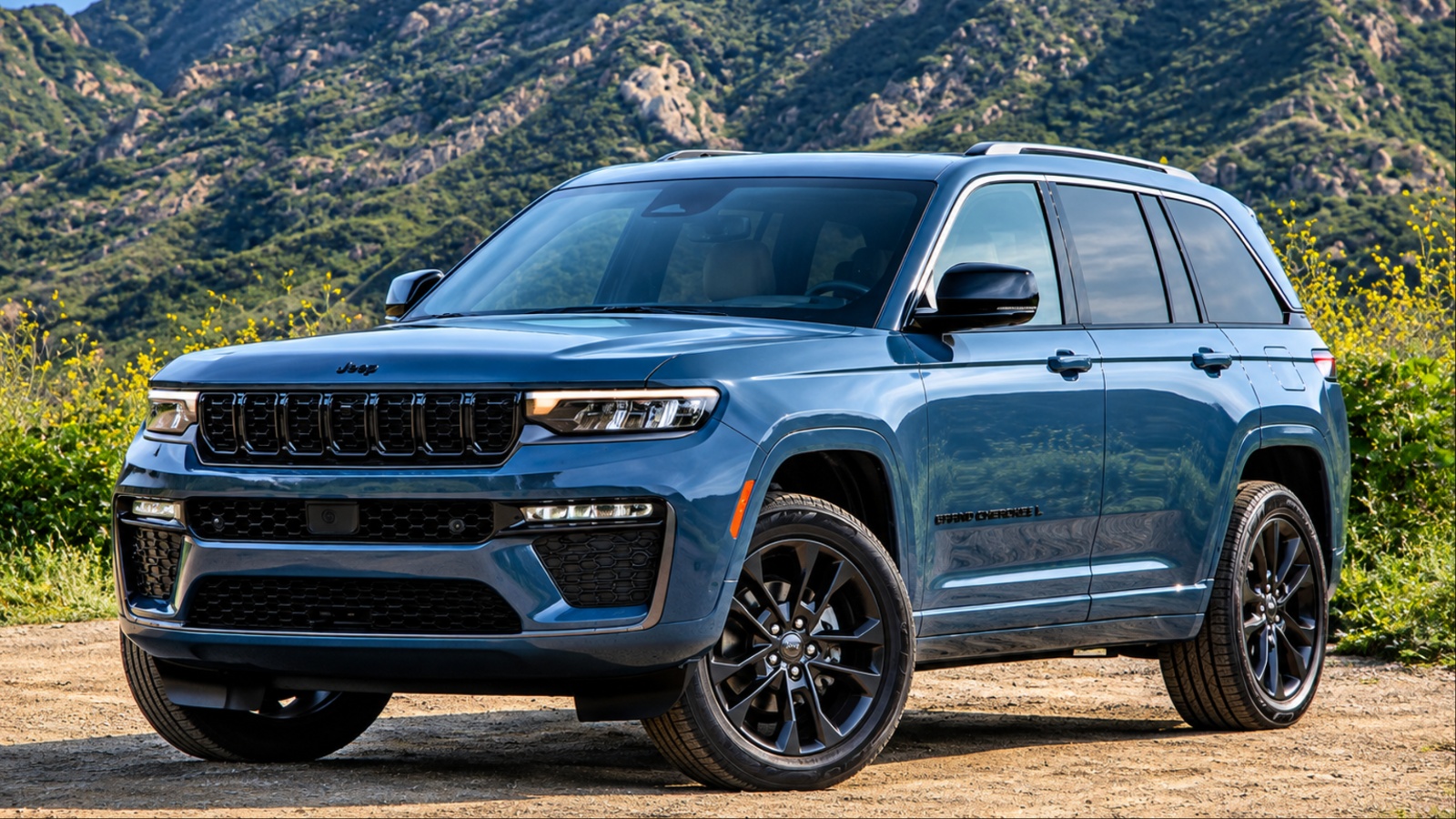 A Jeep Grand Cherokee is standing on the patch of brown soil