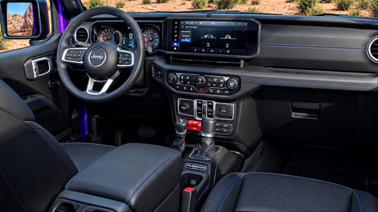 Jeep Rubicon interior with black seats blue stitching and touchscreen