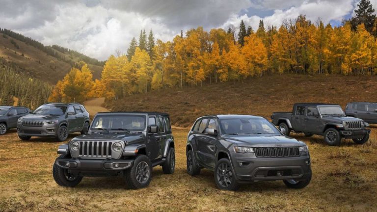 Jeep SUVs and Wrangler models gathered in a scenic mountain landscape during autumn