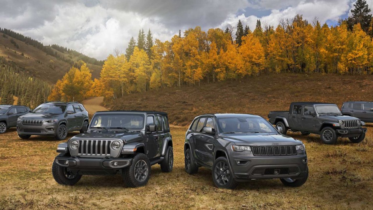 Jeep SUVs and Wrangler models gathered in a scenic mountain landscape during autumn