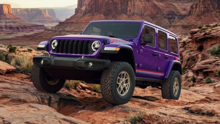 Jeep Wrangler climbing rocky terrain in a dramatic desert canyon landscape