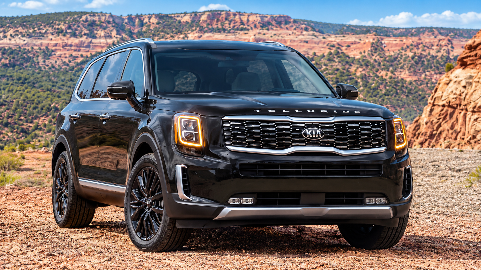 A Kia Telluride sits on a rugged road surrounded by red-rock canyon scenery