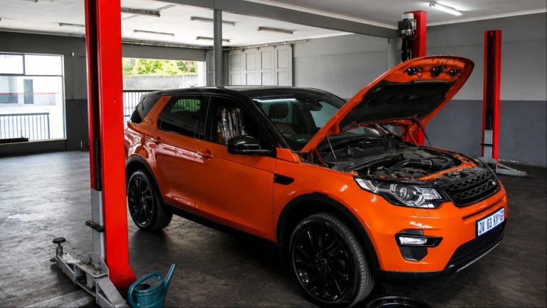 Land Rover Discovery Sport elevated on a two-post lift inside a service bay at Geolander Centre