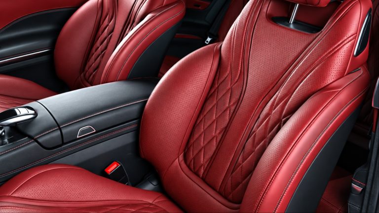 Inside of a car is shown with red leather seats