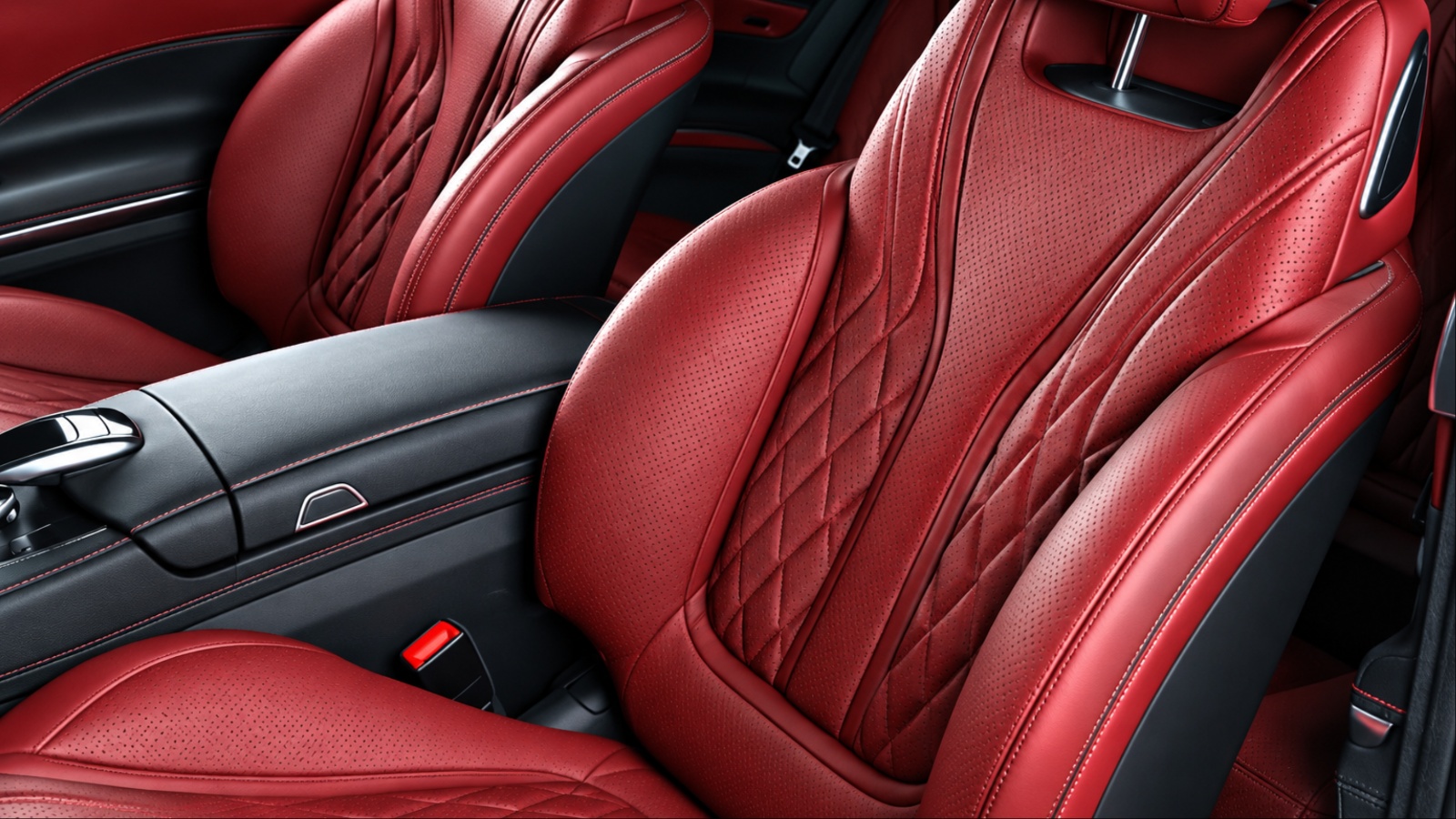 Inside of a car is shown with red leather seats
