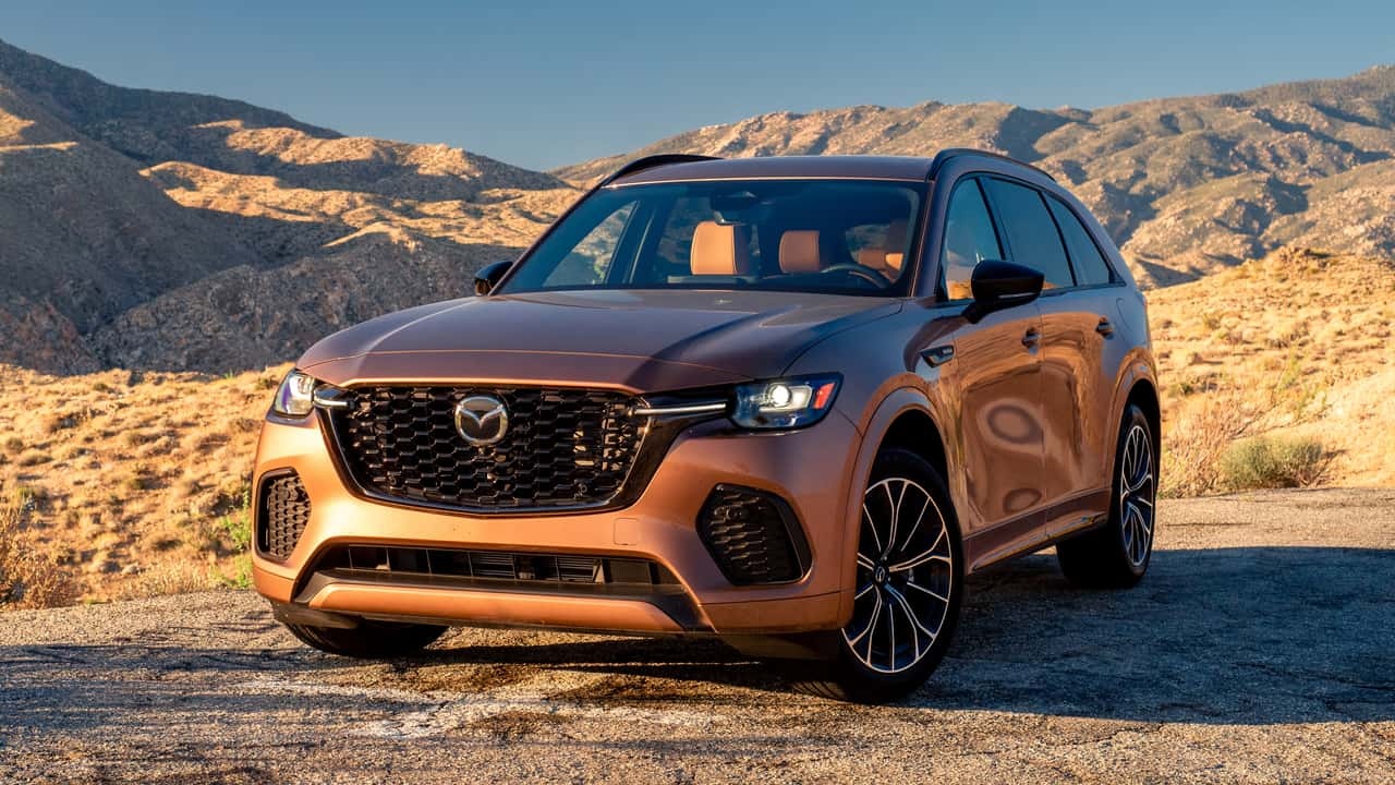 Mazda CX-70 parked along a scenic mountain road at golden hour