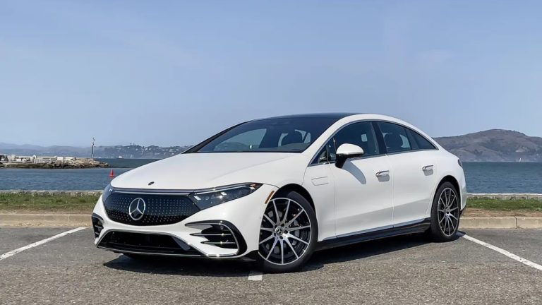 Mercedes-Benz EQS 450+ shown in a coastal setting, highlighting its streamlined electric luxury sedan design