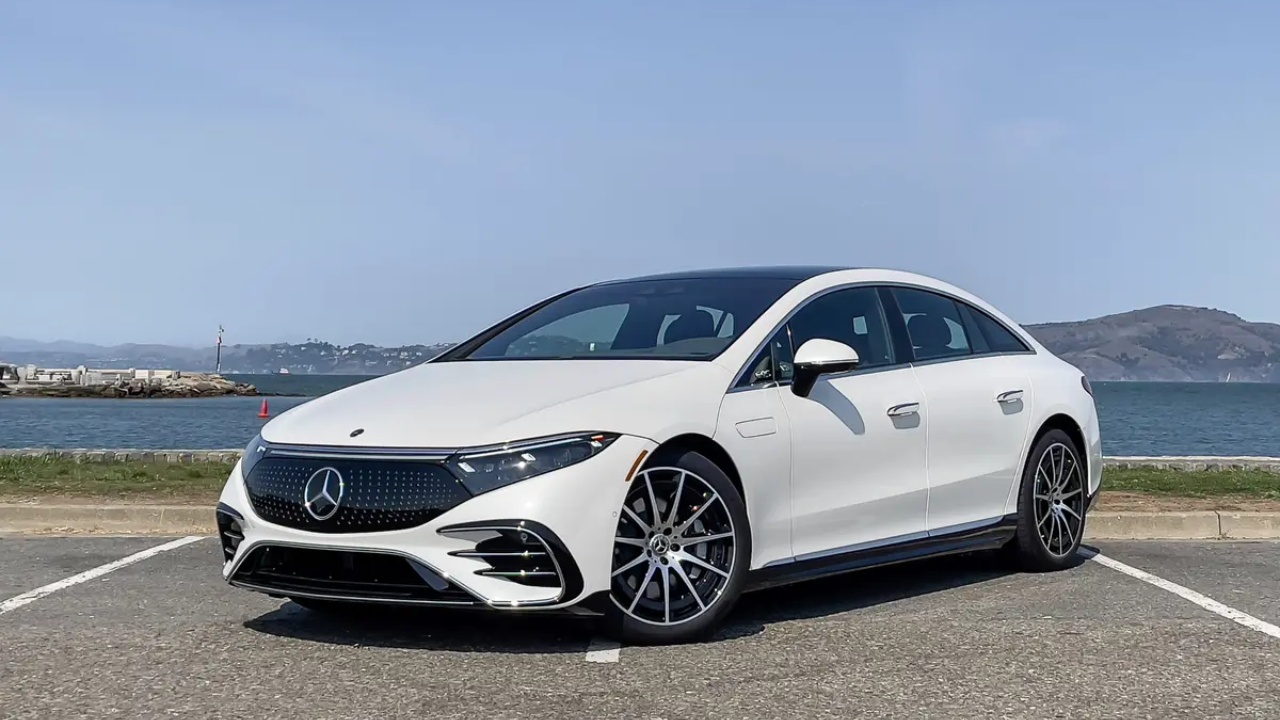 Mercedes-Benz EQS 450+ shown in a coastal setting, highlighting its streamlined electric luxury sedan design