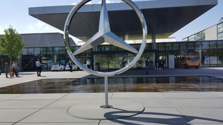 Mercedes-Benz facility entrance featuring the iconic three-pointed star logo and modern architecture