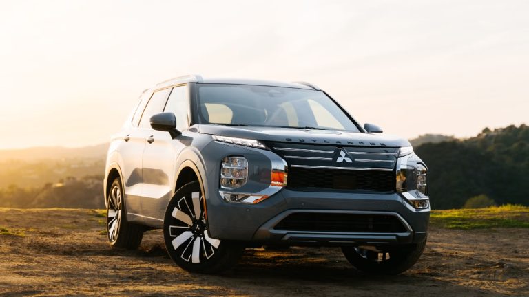 Mitsubishi Outlander parked outdoors during a scenic sunset with rugged surroundings