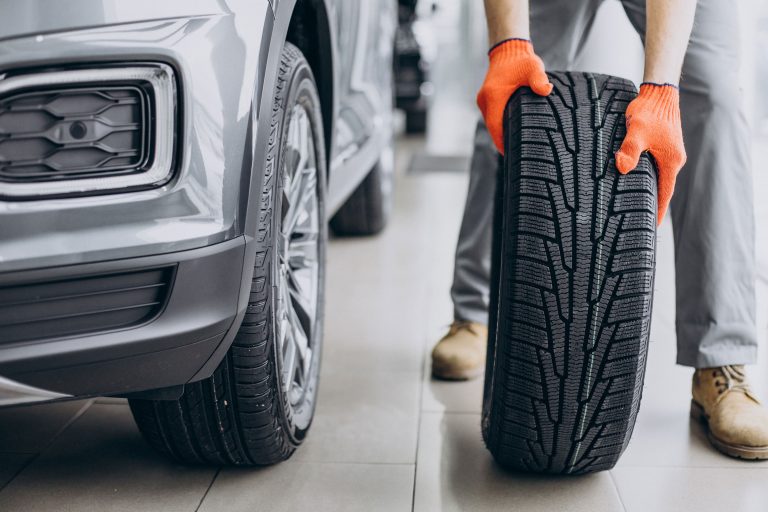 New car tire beside a vehicle