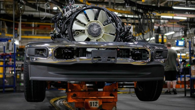 Front of vehicle with engine exposed on factory assembly line