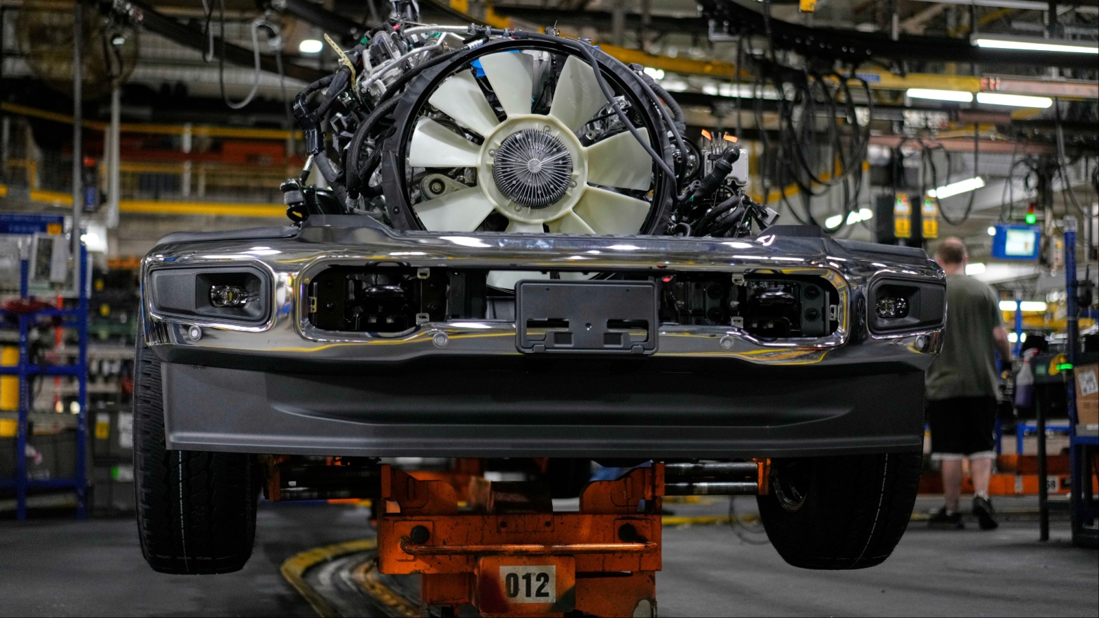 Front of vehicle with engine exposed on factory assembly line