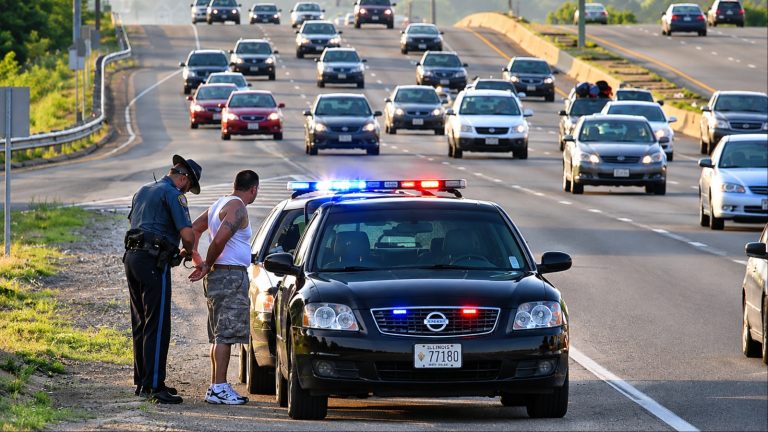 Police officer stopping a driver on a busy highway during a traffic enforcement check