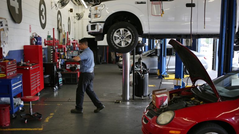 Professional automotive repair shop with multiple vehicles undergoing service