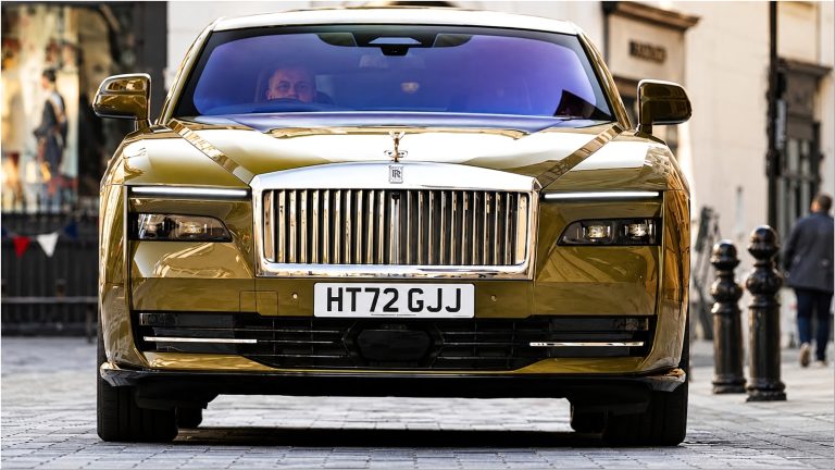 Gold Rolls-Royce Spectre front view driving on city street