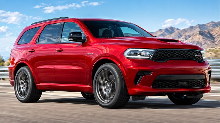 Red Dodge Durango SRT Hellcat driving on a highway, photographed from a front three-quarter angle