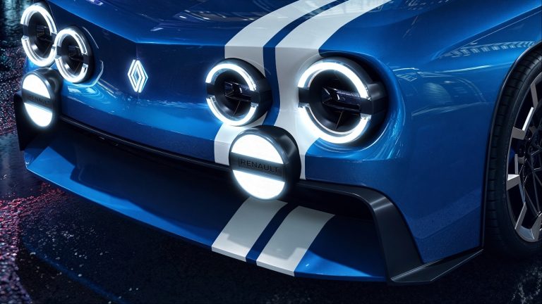 Close-up of blue Renault 8 Gordini with illuminated circular headlights