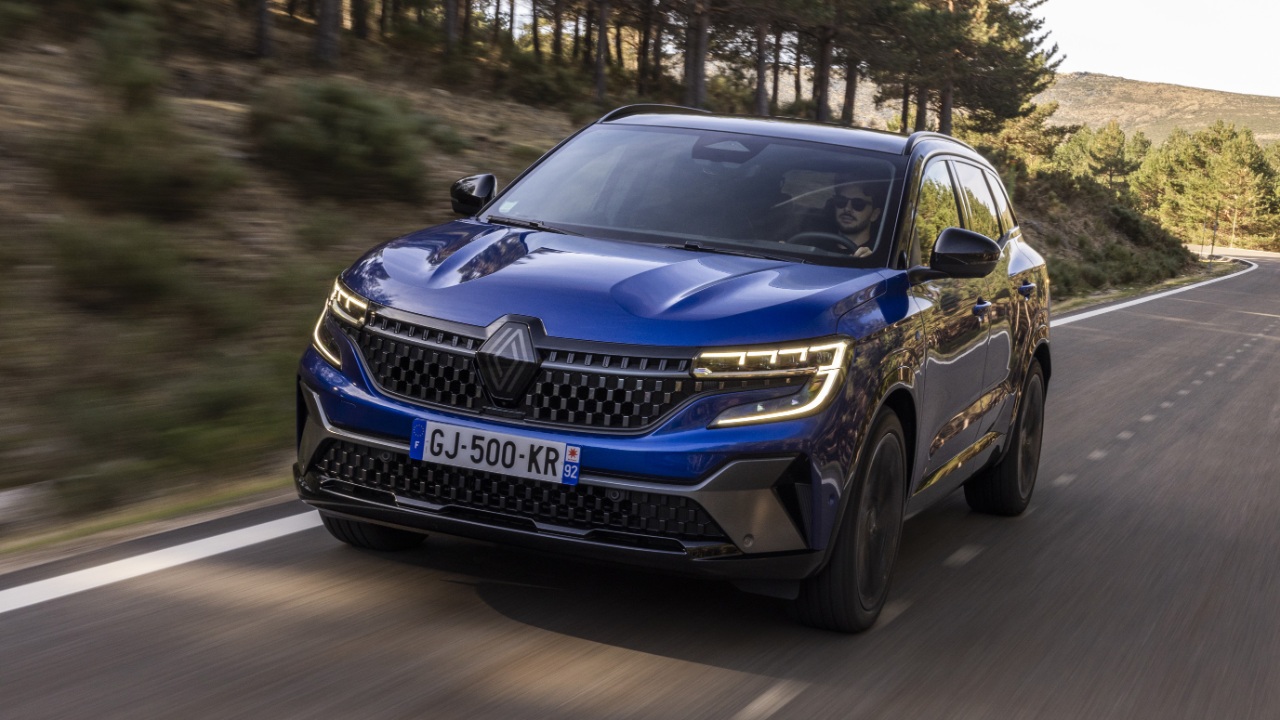 Renault SUV driving along a winding mountain road surrounded by forest