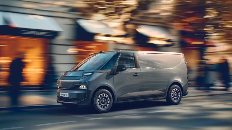 Renault Trafic E-Tech Electric van drives through a busy urban street
