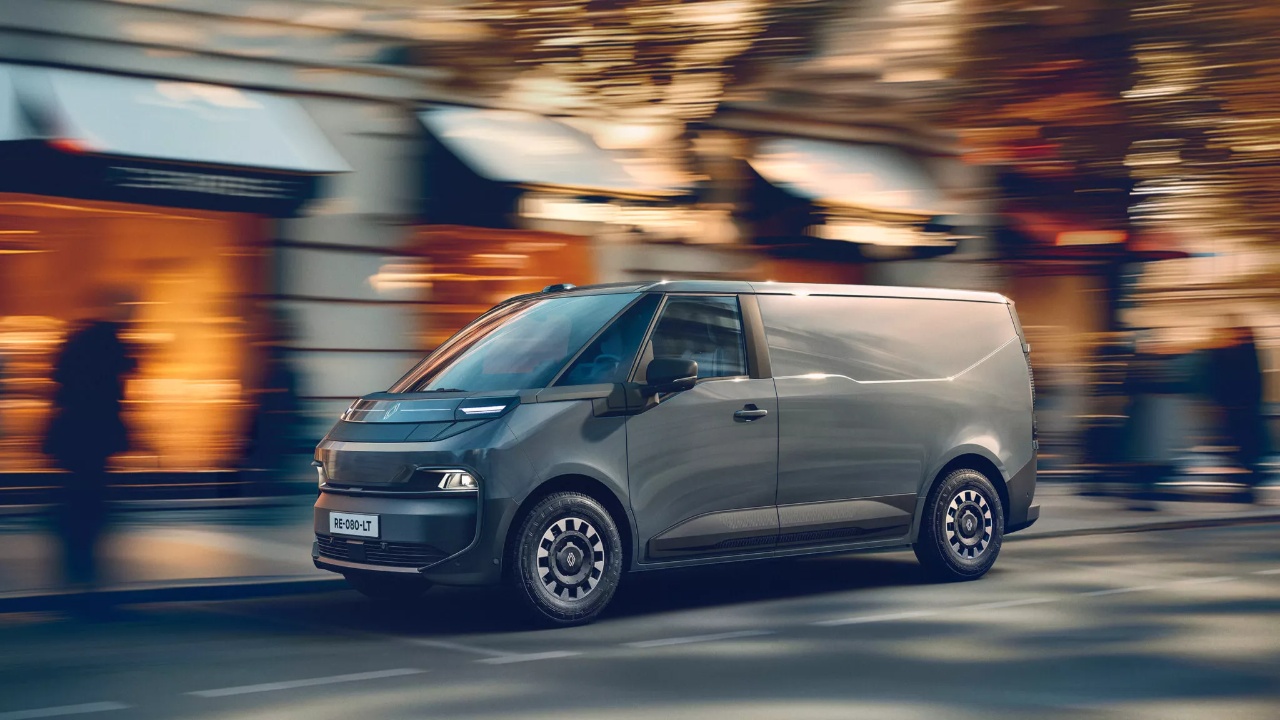 Renault Trafic E-Tech Electric van drives through a busy urban street