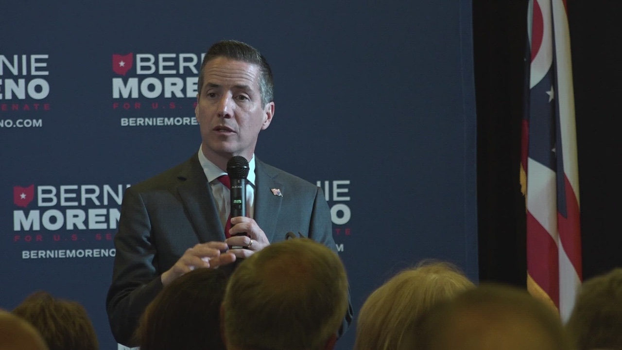 Republican Senator Bernie Moreno speaks into a microphone during a public event