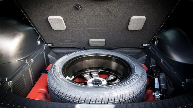 Spare tire stored beneath the vehicle’s cargo floor with essential tools