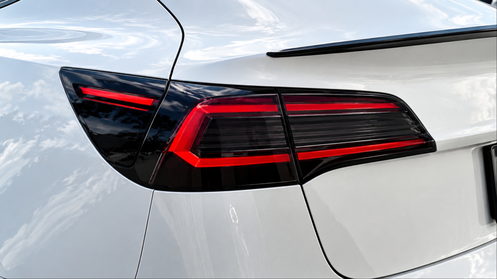 Close-up of white car rear featuring modern tinted red taillights