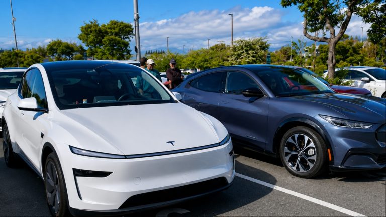 Tesla and Ford electric vehicles parked together under bright daylight