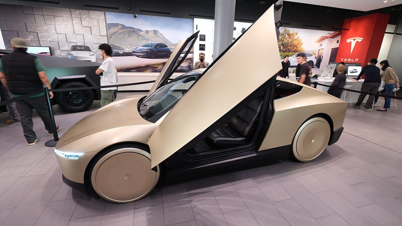 Tesla Cybercab displayed with its distinctive doors open inside a showroom