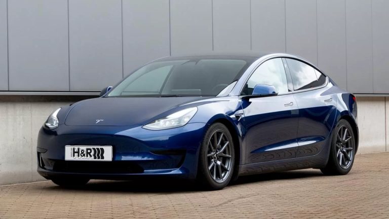 Tesla Model 3 parked outside a modern building, showcasing its sleek electric sedan design