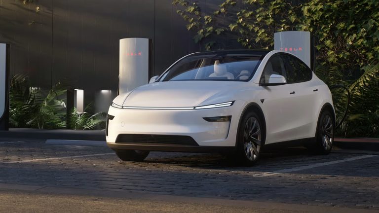 Tesla Model Y parked at a Tesla Supercharger station, surrounded by greenery