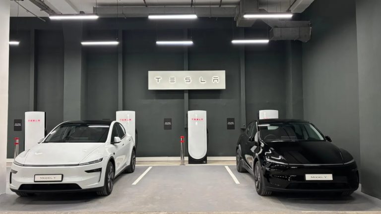 Tesla Model Y vehicles charging inside a modern Tesla Supercharger station