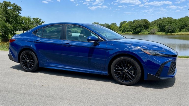 A Camry is standning on a road on a sunny day