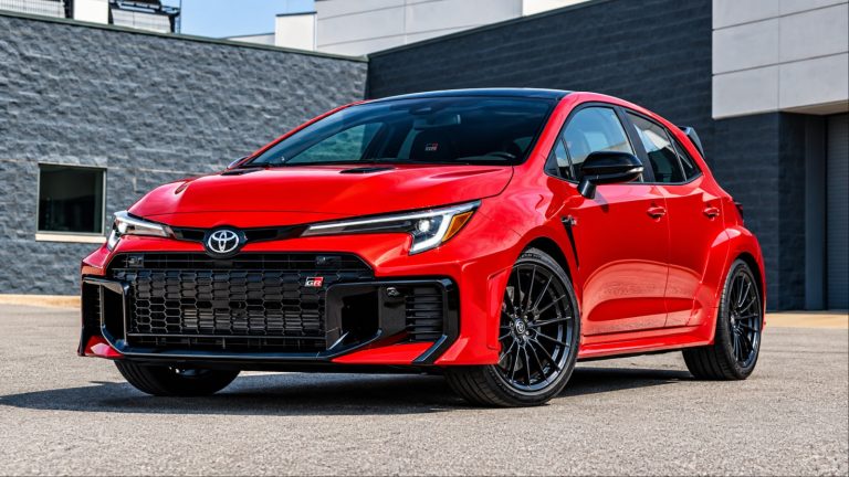 bright red Toyota Corolla parked outside a modern building
