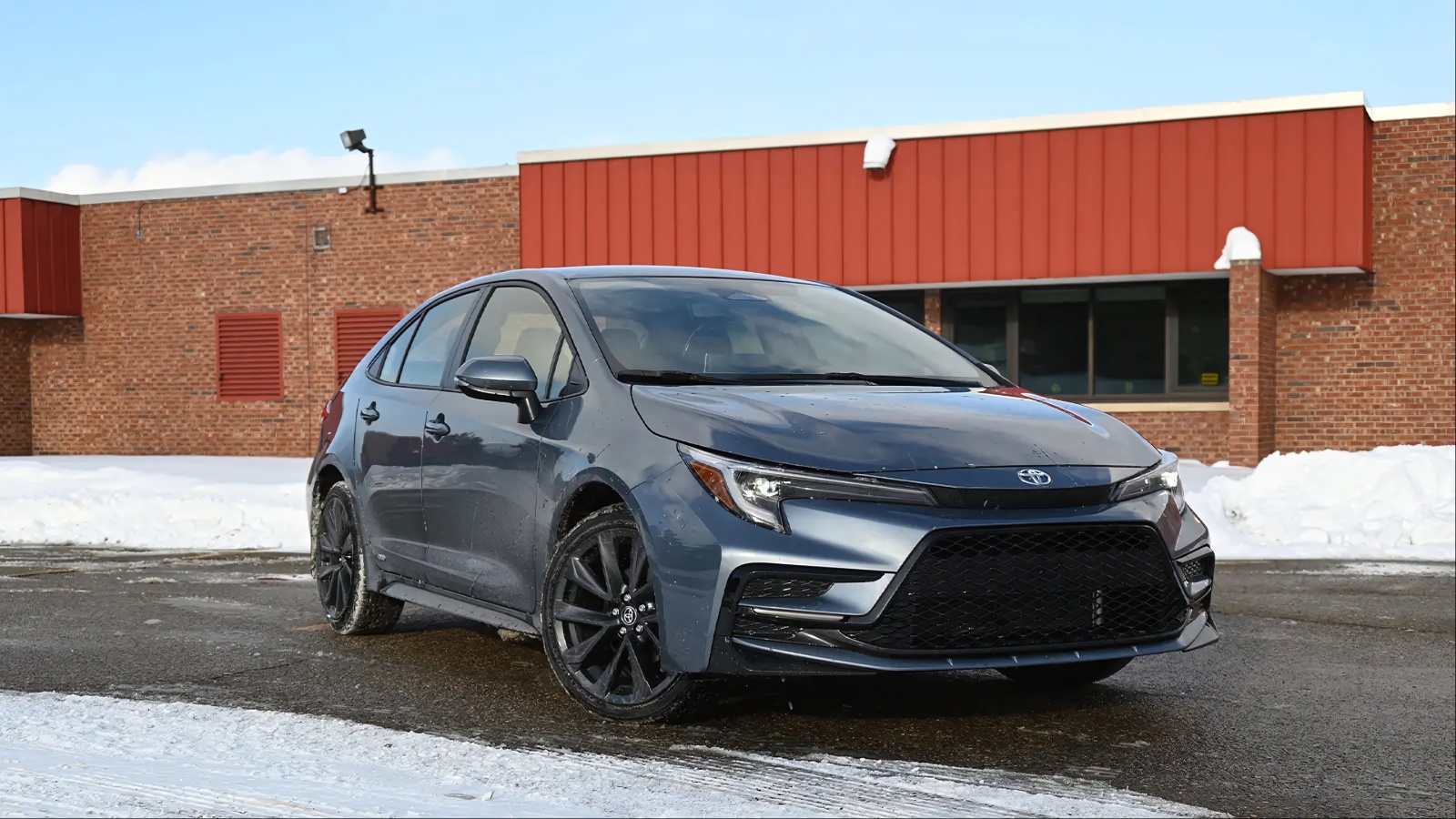 A Toyota Corolla is standing in front of a building