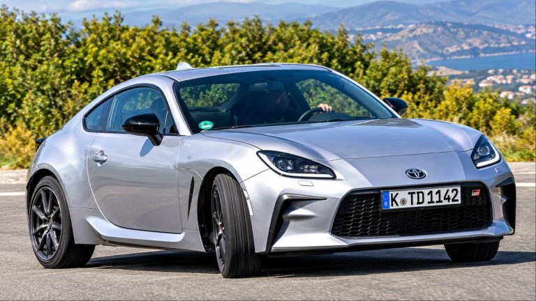 A Toyota GR86 speeds through a winding road with sporty styling and sharp handling