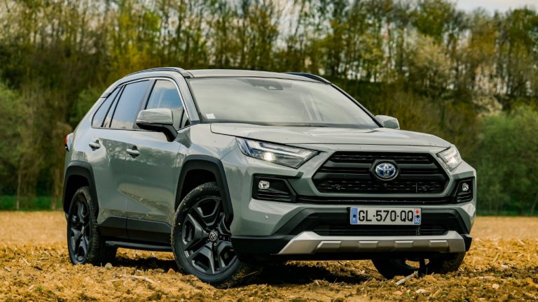 Toyota RAV4 parked on a field with trees and soft evening light