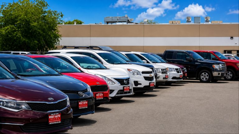 Used car dealership lot with rows of cars and SUVs for sale