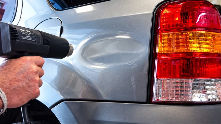 Using a heat gun to repair a dented car body panel