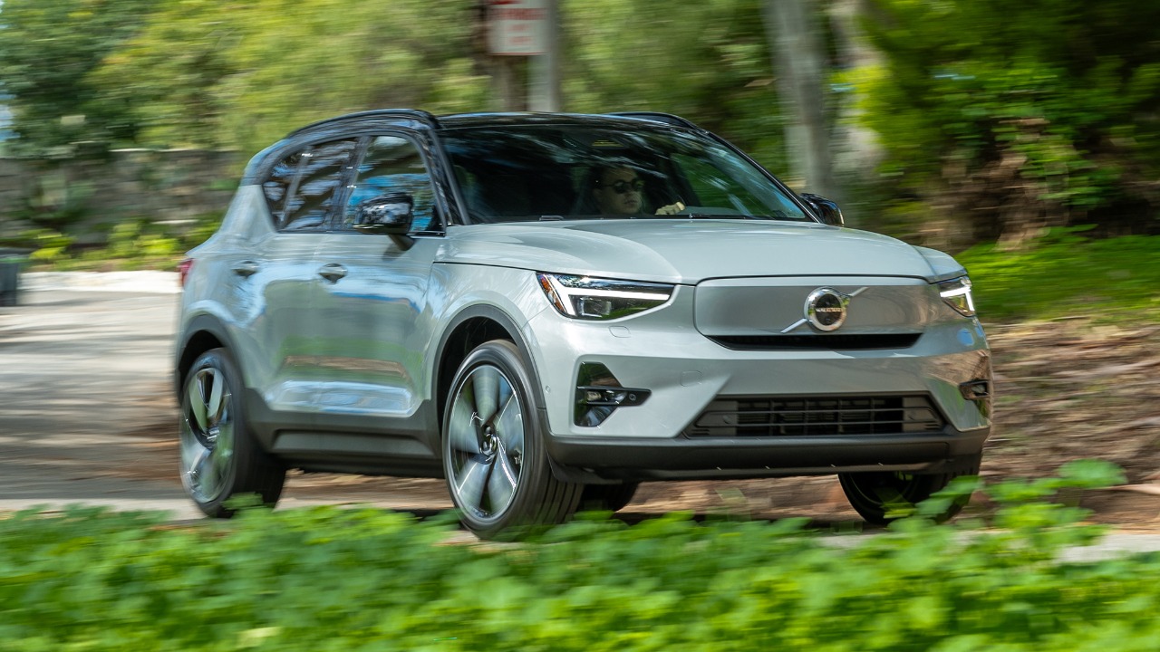 Volvo XC40 driving through a lush forest road, captured with dynamic motion blur