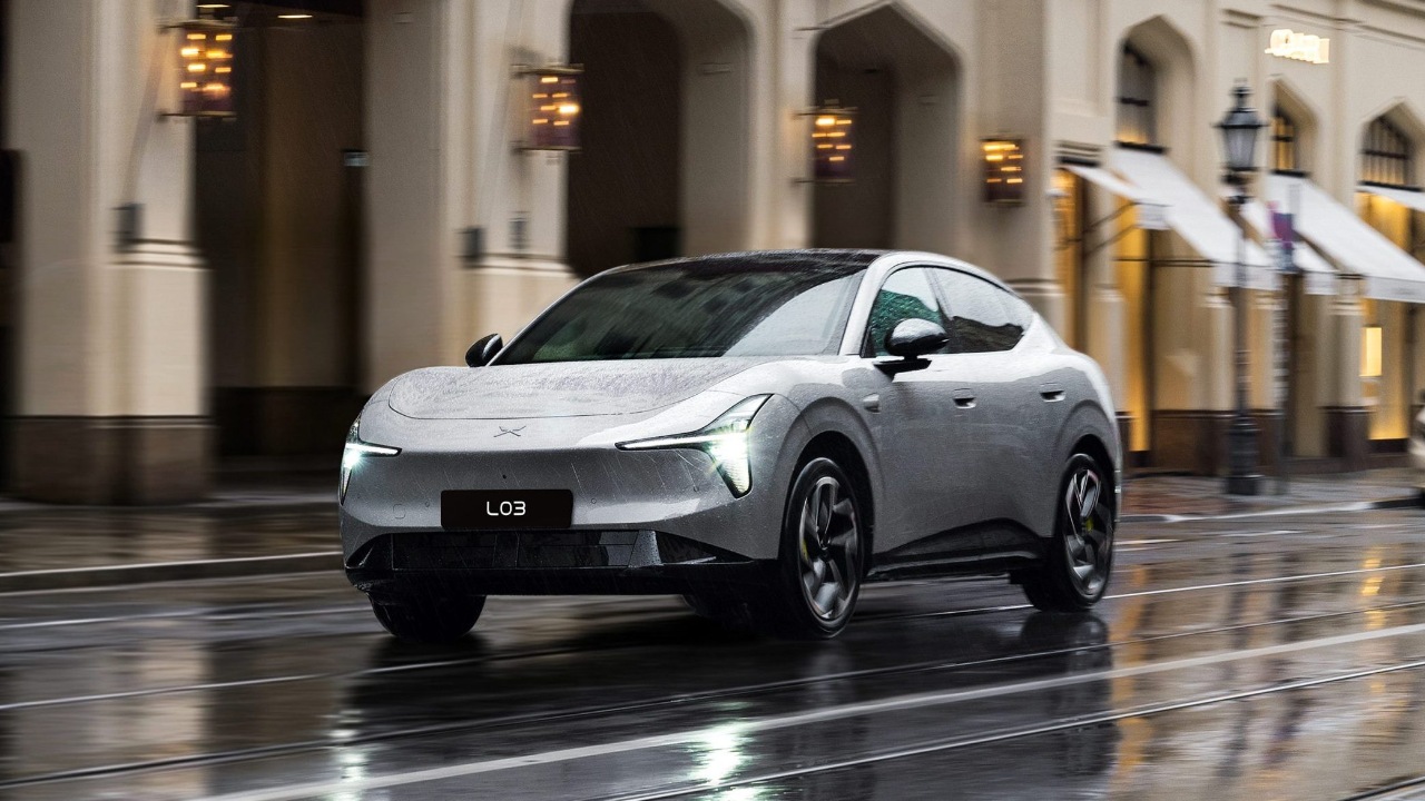 White Lynk & Co L03 electric sedan driving through a rainy city street