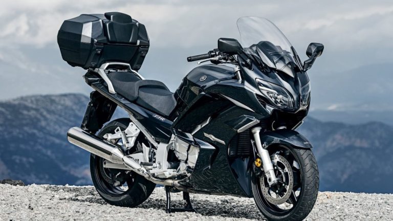 Yamaha touring motorcycle parked on rocky terrain overlooking mountains
