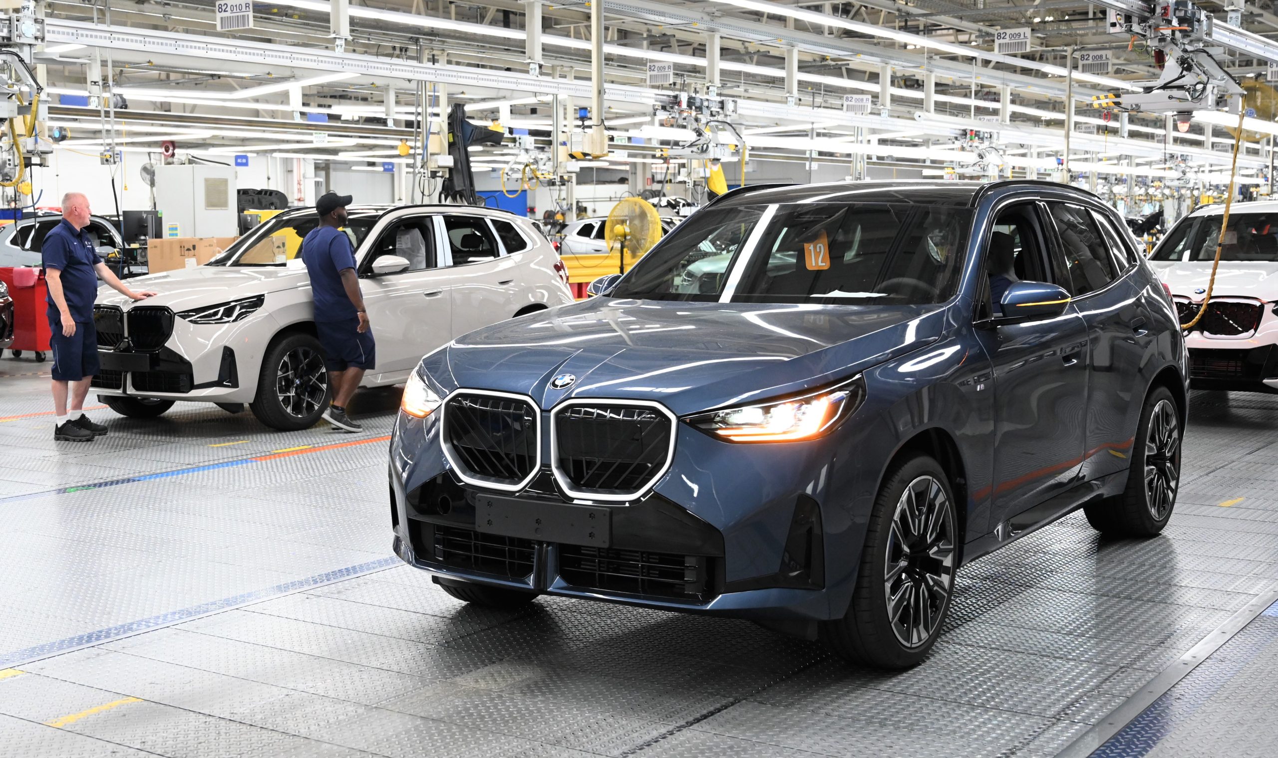 2 BMWs are getting setup inside a factory