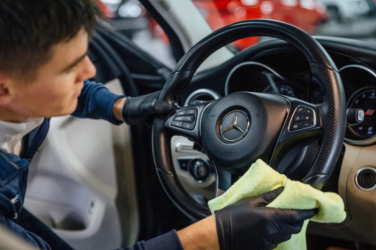 Person cleaning and restoring a car steering wheel